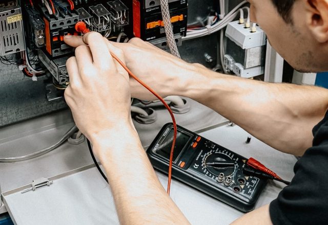 Electrician testing an electrical panel with a multimeter