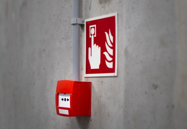 Wall-mounted fire alarm call point in a commercial building