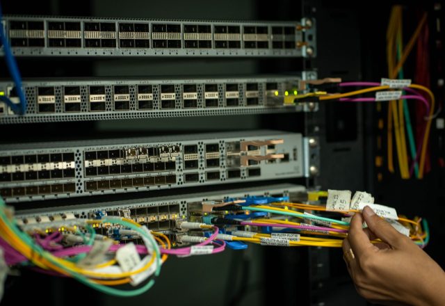 Technician terminating fibre patch cables on a network switch